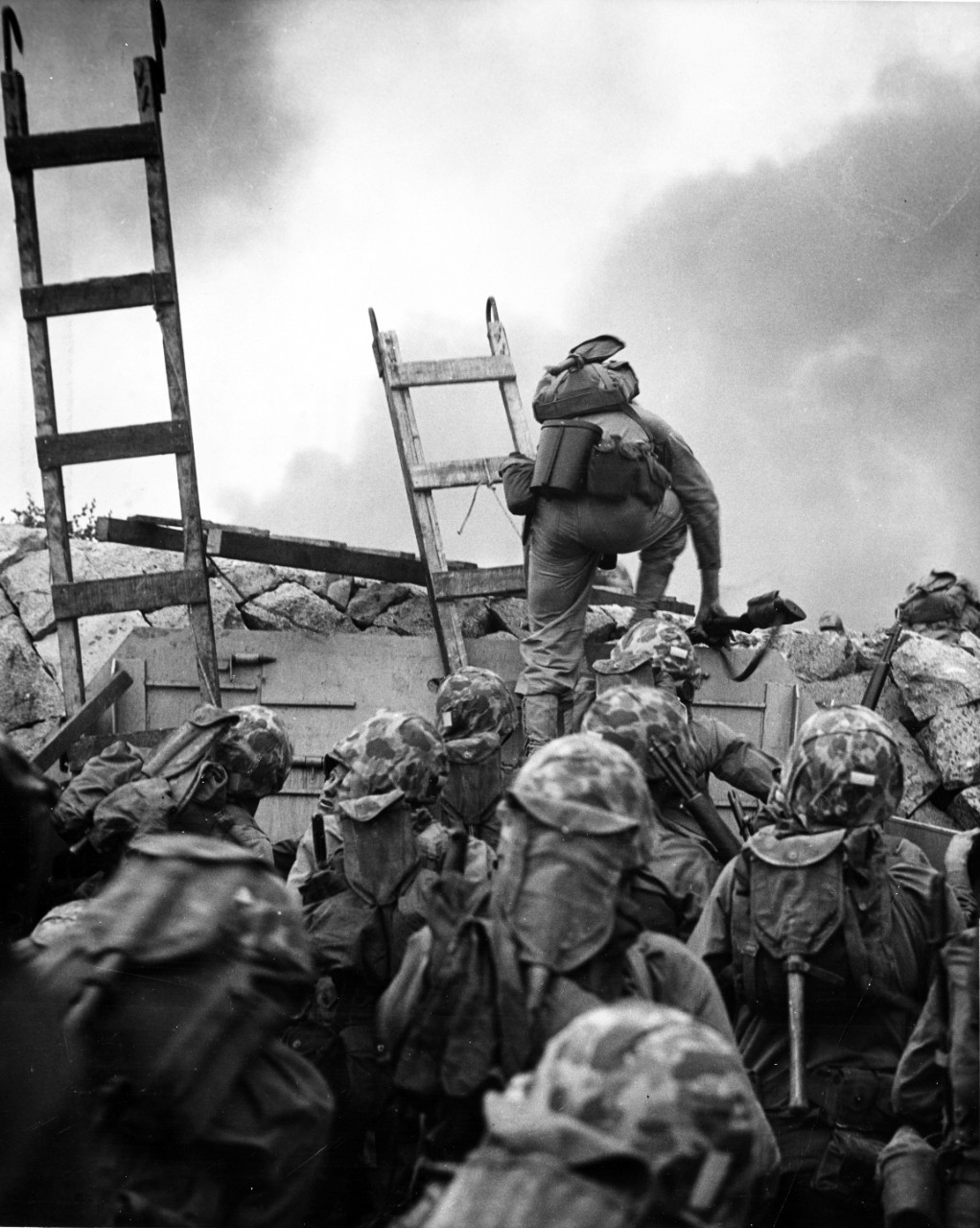 First Lieutenant Baldomero Lopez, USMC, leads the 3rd Platoon, Company A, 1st Battalion, 5th Marines over the seawall on the northern side of Red Beach, as the second assault wave lands, 15 September 1950.