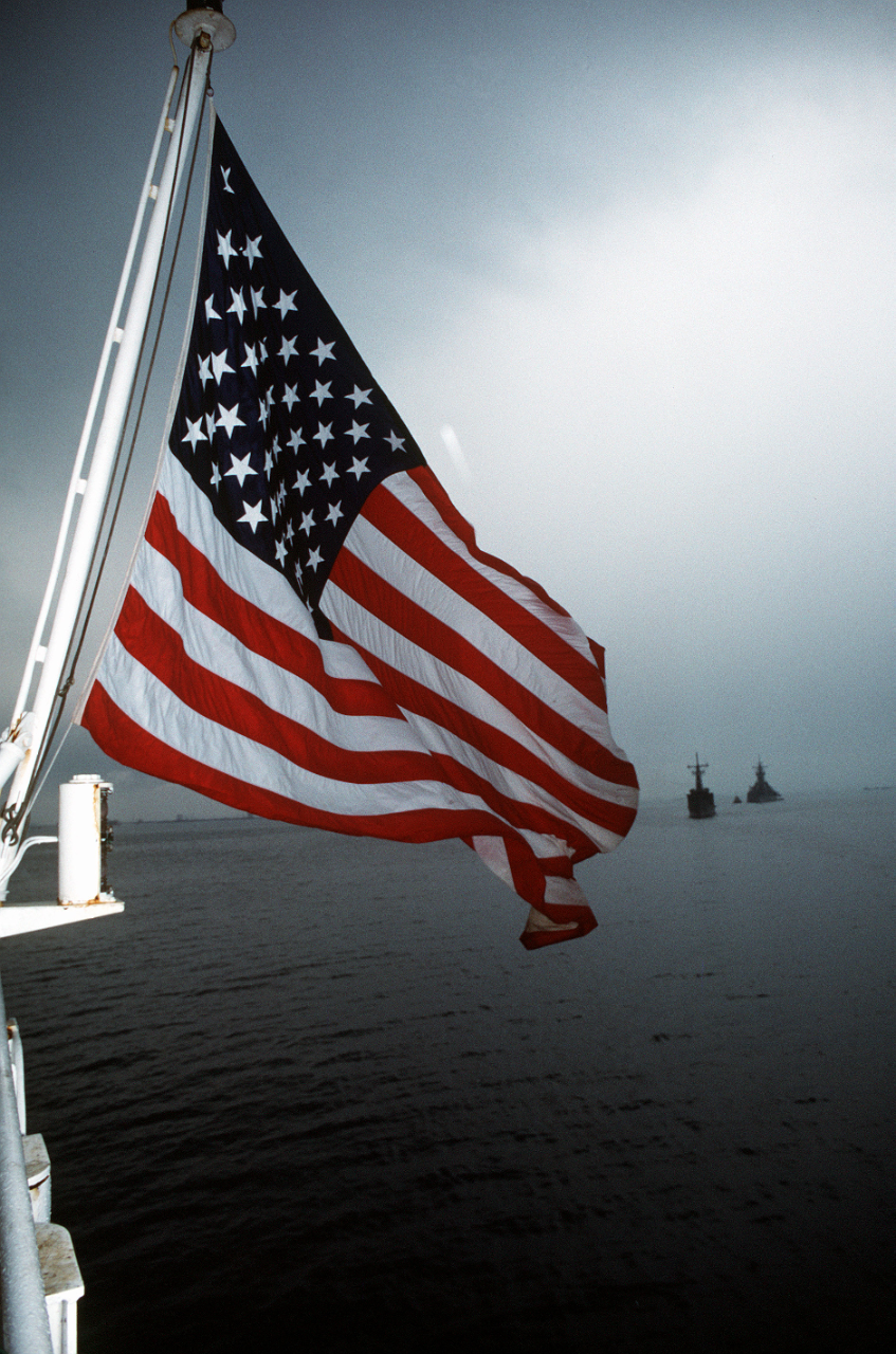 photo of a U.S. flag flying off a ship at sea