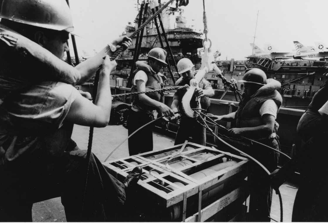 ship crewmen transferring bombs between 2 ships