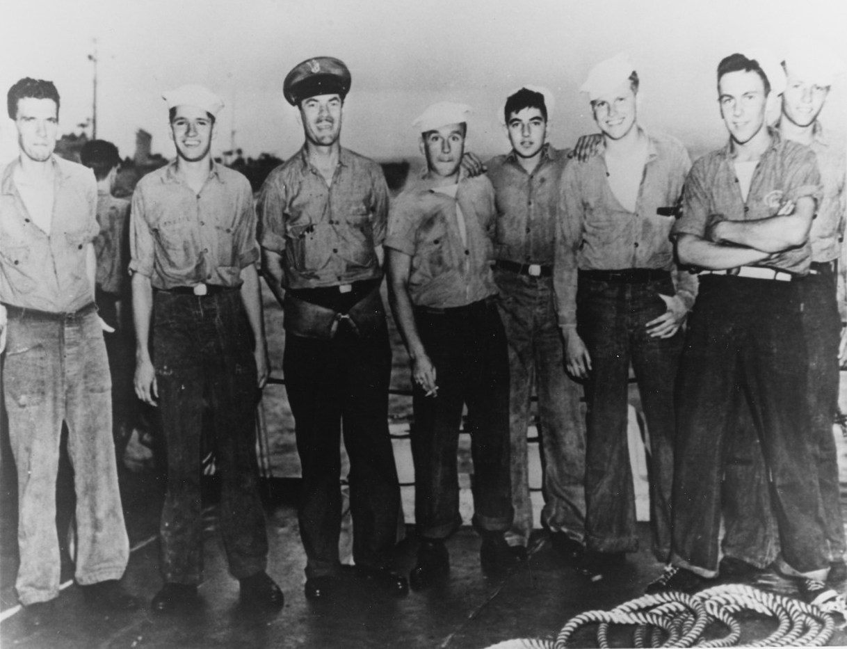 7 men in Navy uniform posing on a ship