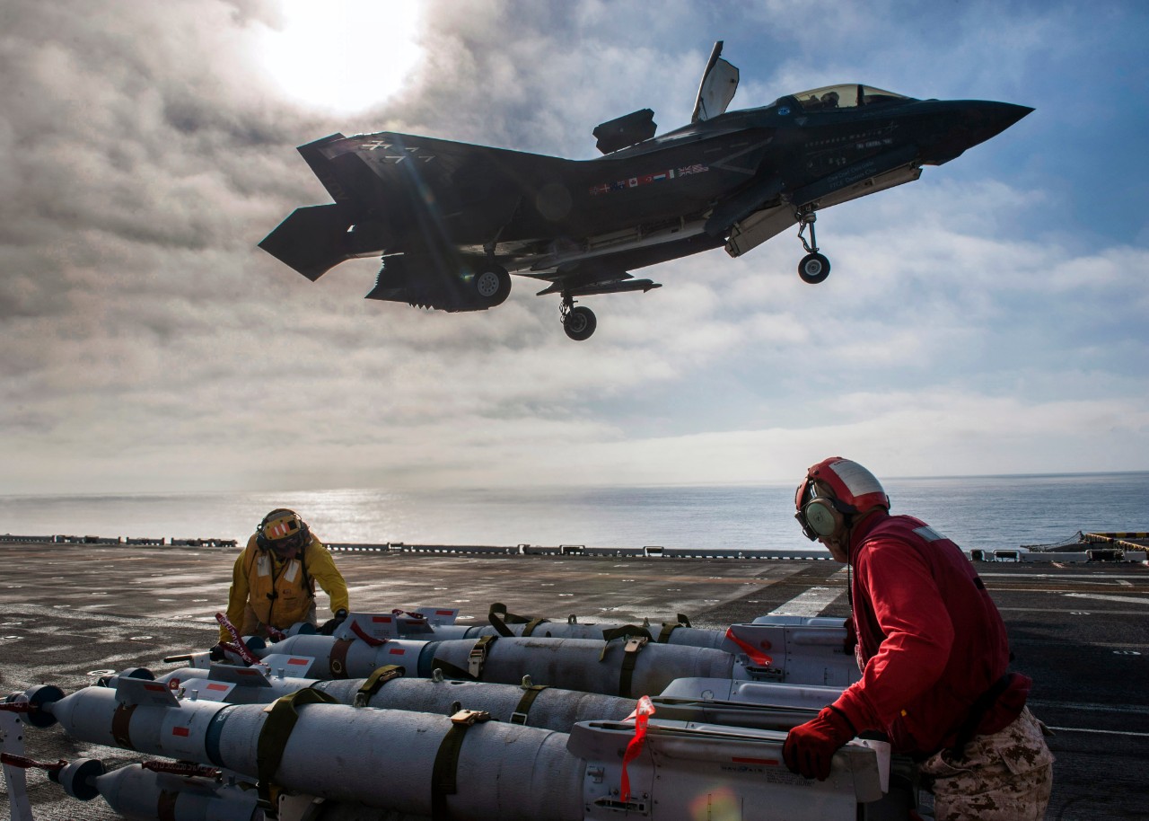 161105-N-VR008-0208 PACIFIC OCEAN (Nov. 5:: 2016) Sailors assigned to the amphibious assault ship USS America (LHA 6) and F-35B Lightning II Marine Corps personnel prepare to equip the aircraft with inert 500-pound GBU-12 Paveway II laser-guided ...