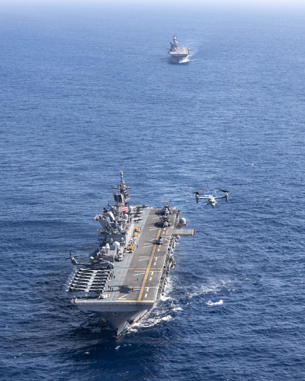 Philippine Sea (Sept. 17, 2022) A U.S. Marine Corps MV-22B Osprey helicopter takes off from the amphibious assault ship USS Tripoli (LHA 7) as it sails in front of USS America (LHA 6) during a photo exercise in the Philippine Sea, Sept. 17, 2022....