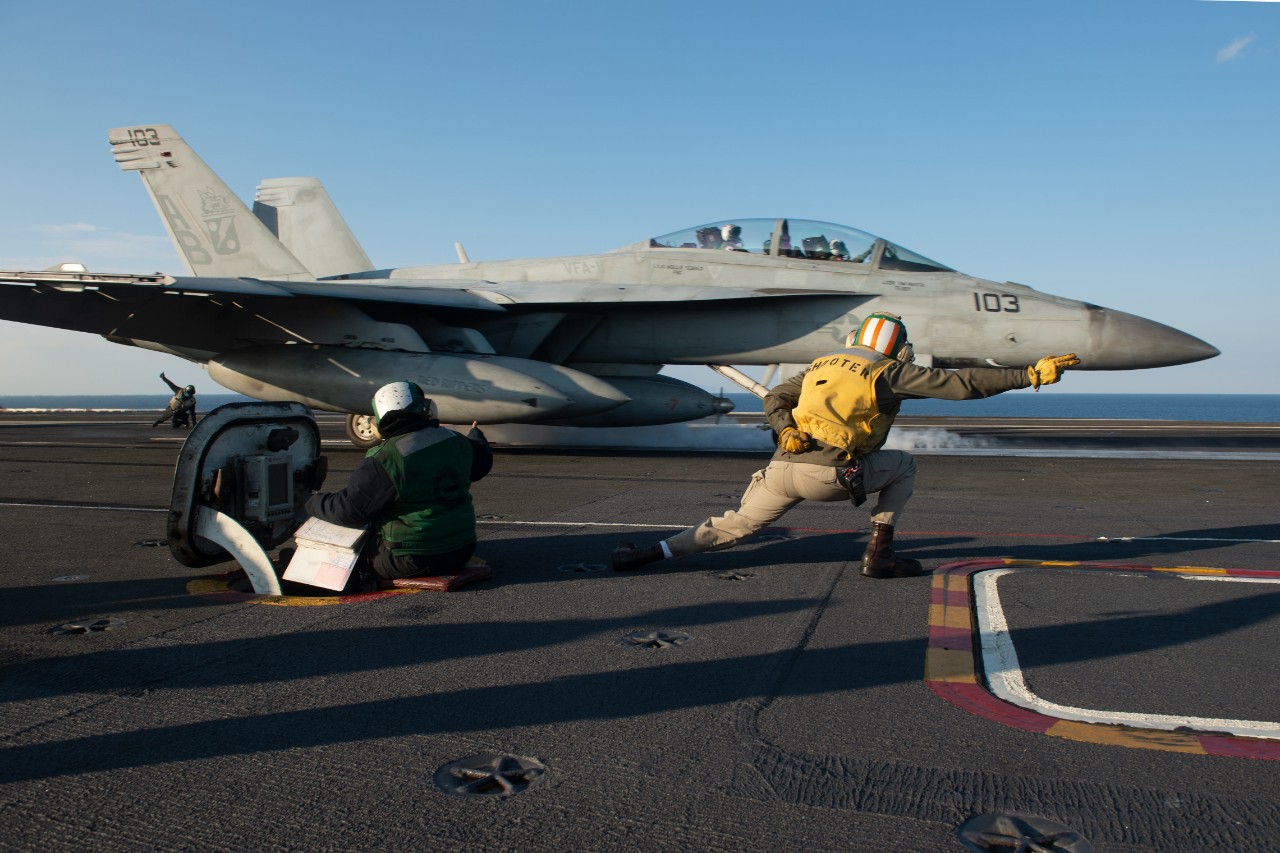 AEGEAN SEA (March 4, 2022) Lt. Zachary Collver, from Arlington, Washington, signals to the pilot of an F/A-18F Super Hornet, attached to the ÒRed RippersÓ of Strike Fighter Squadron (VFA) 11, before launching from the flight deck of the Nimitz-cl...