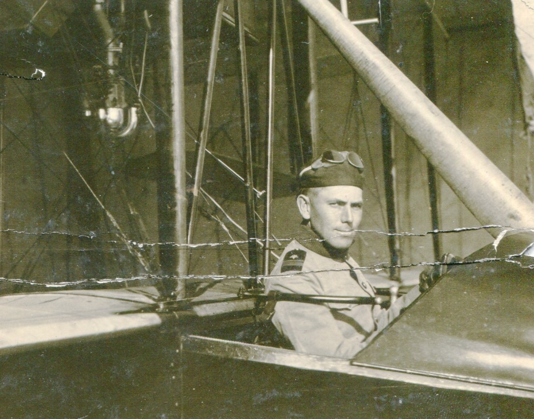<p>Portrait of a man in uniform in the pilot seat of a biplane.&nbsp;</p>