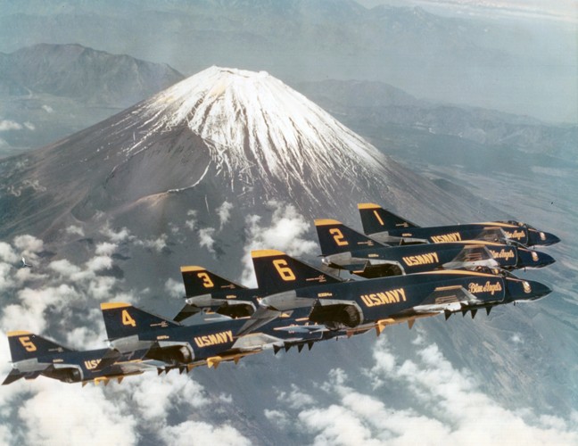 Six Blue Angels F-4 Phantoms flying in formation past a mountain