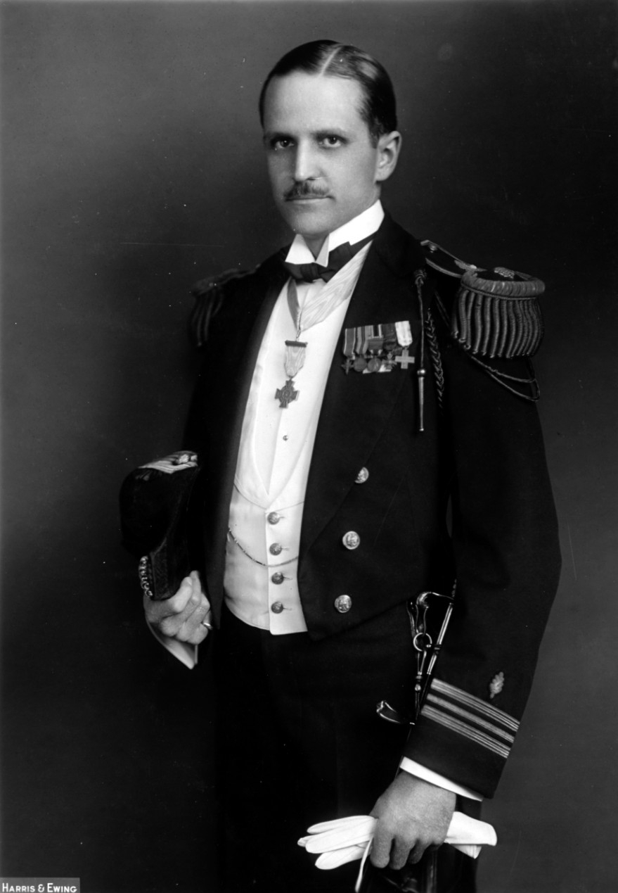 photo of man in full dress Navy uniform with a medal of honor around his neck
