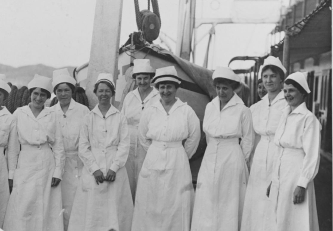Nurses in white dresses (uniform) group together on USS Relief (AH-1).