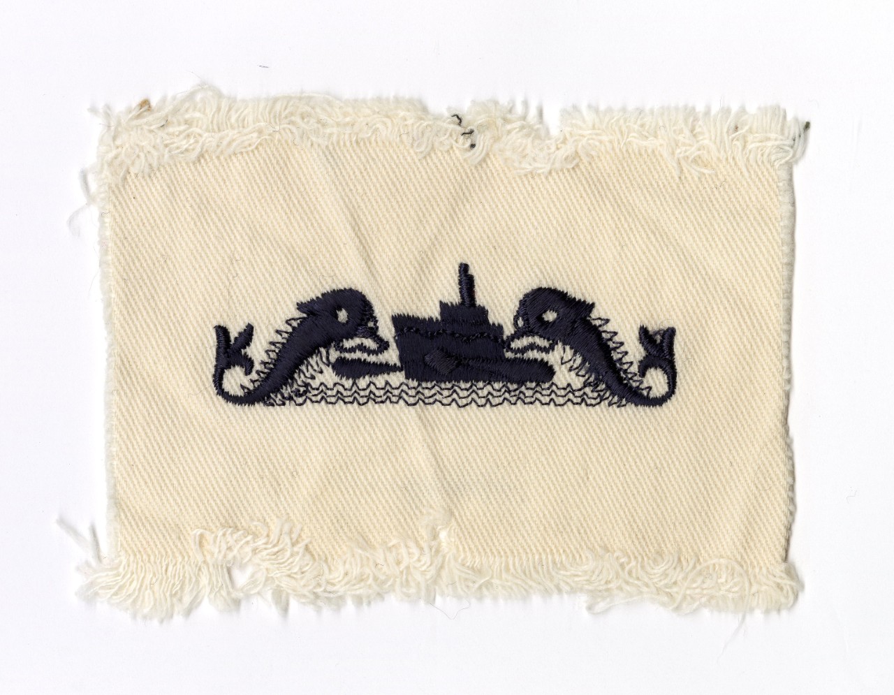 embroidered design in blue thread on white cloth of two fish flanking a submarine