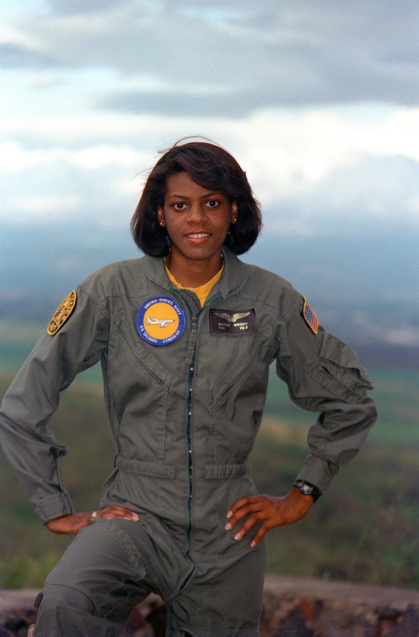 Portrait of an African American woman standing in a Navy flight suit.
