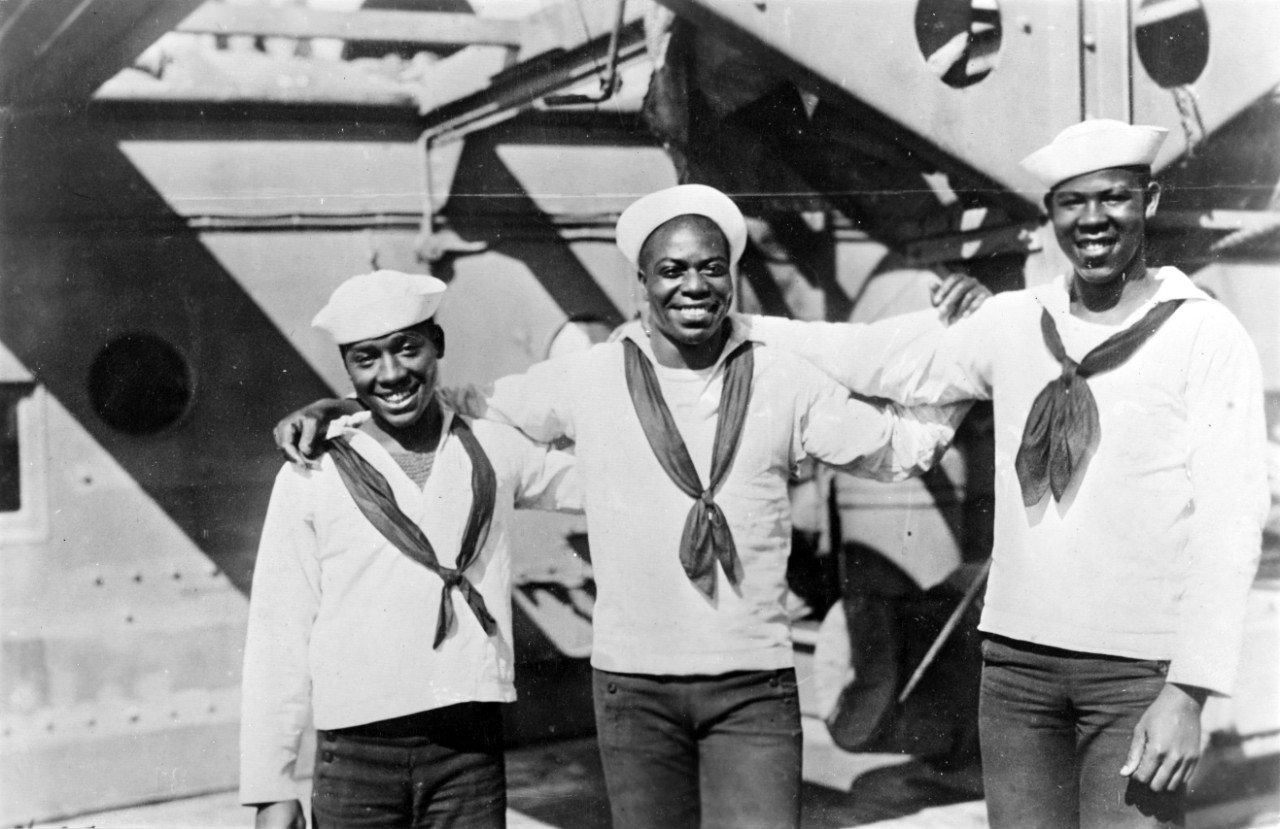 A group of three African American sailors on the deck of the submarine tender Bushnell (AS-2) during World War I (NH 56659).