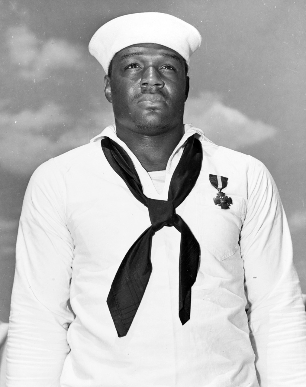 Mess Attendant Second Class Doris Miller just after being presented with the Navy Cross by Admiral Chester W. Nimitz on board the aircraft carrier Enterprise (CV-6) at Pearl Harbor, 27 May 1942. Official U.S. Navy Photograph, now in the collectio...