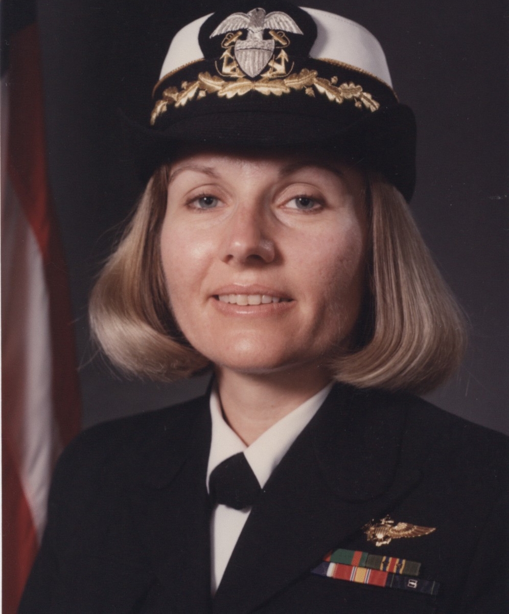 Portrait of a white woman in blue Navy uniform.