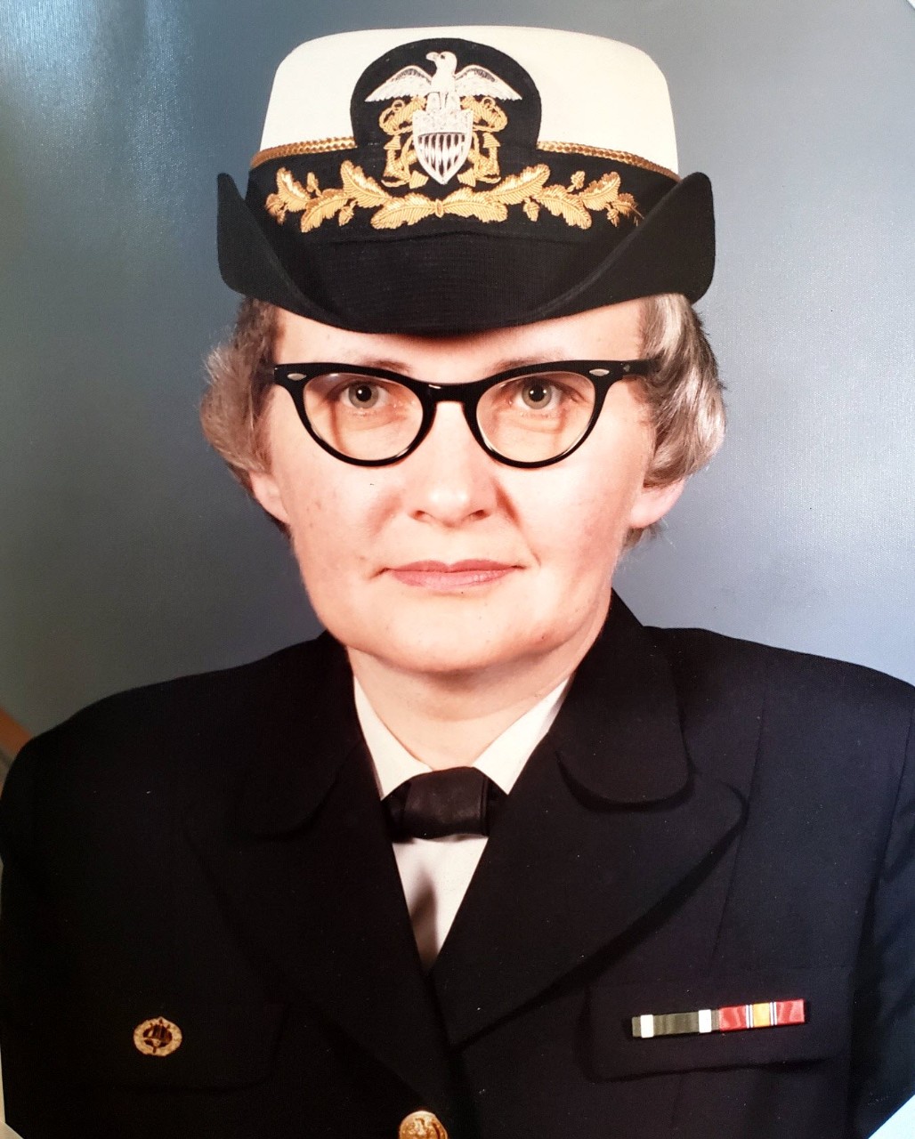 White woman wearing glasses in naval uniform and bucket hat