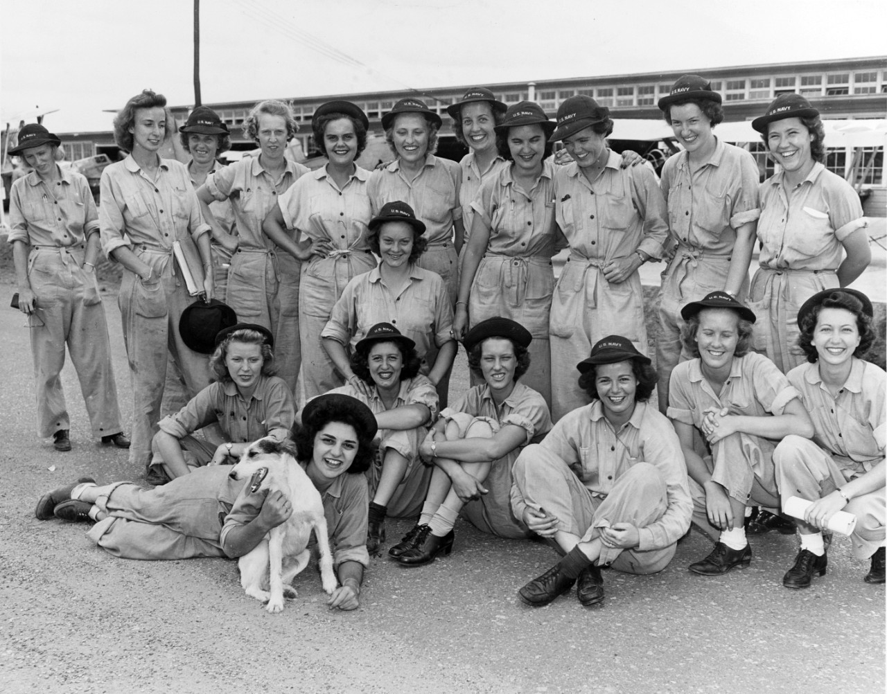 Group photo of women in cover working coveralls and hats inscribed with U.S. Navy.