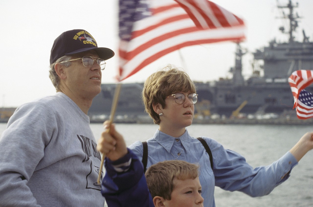 Dale Hamby, husband of LCDR Janice Hamby of the Operations Department on board the nuclear-powered aircraft carrier USS Dwight D. Eisenhower (CVN-69), waves goodbye along with their two children, as the ship deploys for a six-month deployment to ...