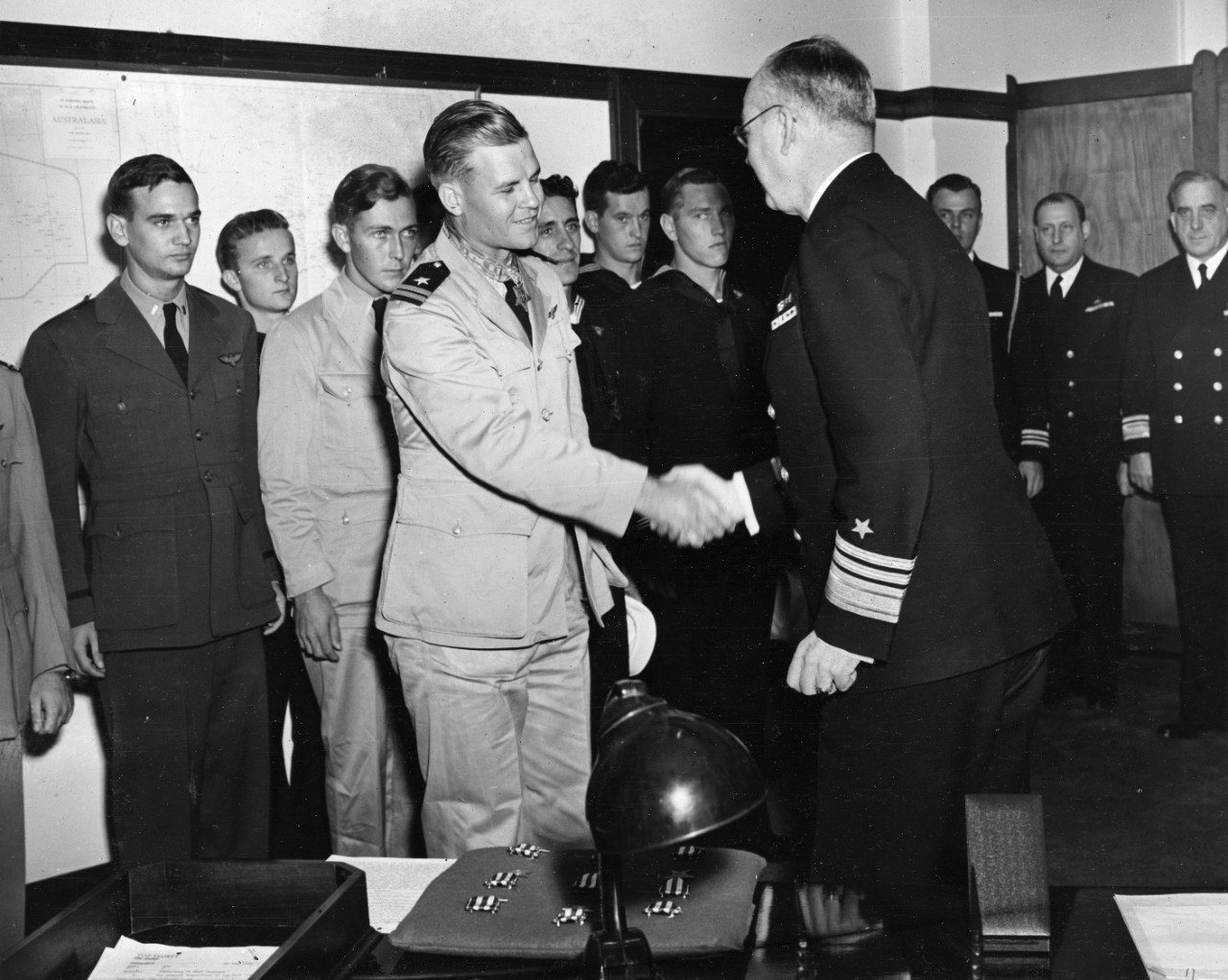 Vice Admiral Thomas C. Kinkaid, USN (right) (Commander, Seventh Fleet) and Lieutenant Nathan G. Gordon, USNR (left) shaking hands after Gordon was presented the Medal of Honor at Seventh Fleet Headquarters on 19 August 1944.