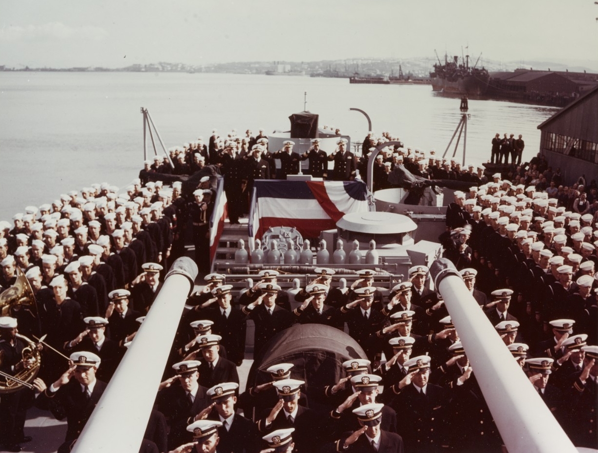 USS Flint (CL-97) ship's officers saluting during her commissioning ceremonies, at the Bethlehem Steel Company shipyard, San Francisco, California, on 31 August 1944.