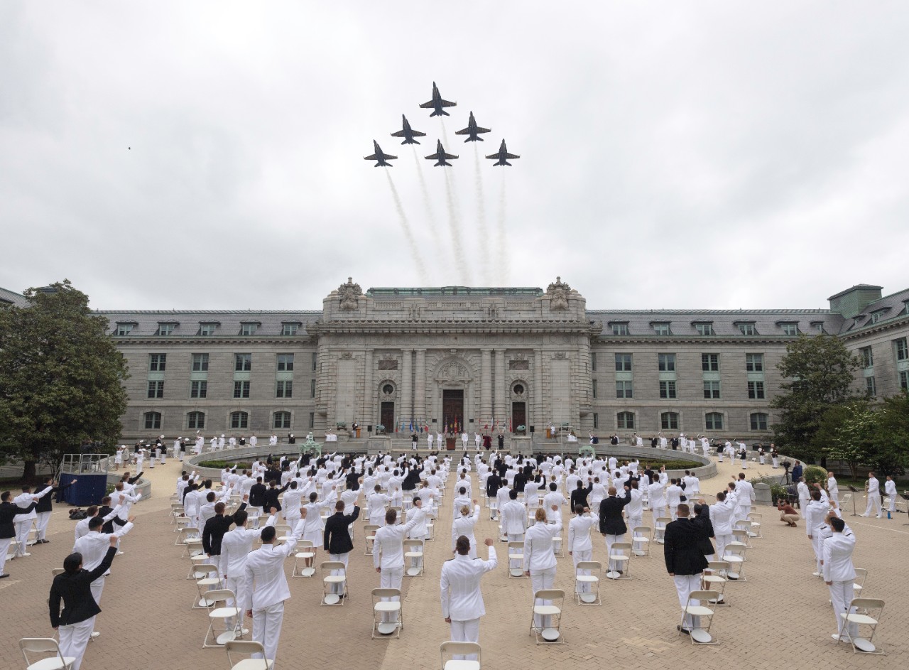 The U.S. Navy Flight Demonstration Squadron, the Blue Angels, fly over Bancroft Hall as midshipmen sing the alma mater, "Navy Blue and Gold," during the fifth swearing-in event for the United States Naval Academy Class of 2020.    