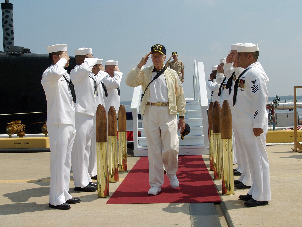President Carter walks through a row of saluting sailors. 