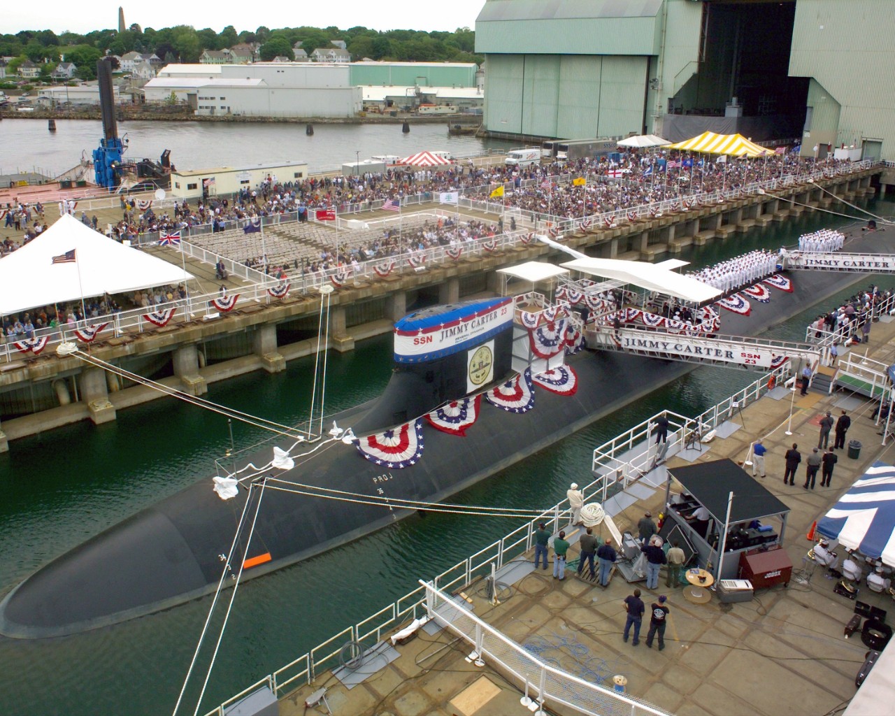 Aerial view of submarine with onlookers on dock. 