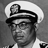 <p>A portrait of a black man in white naval uniform.&nbsp;</p>