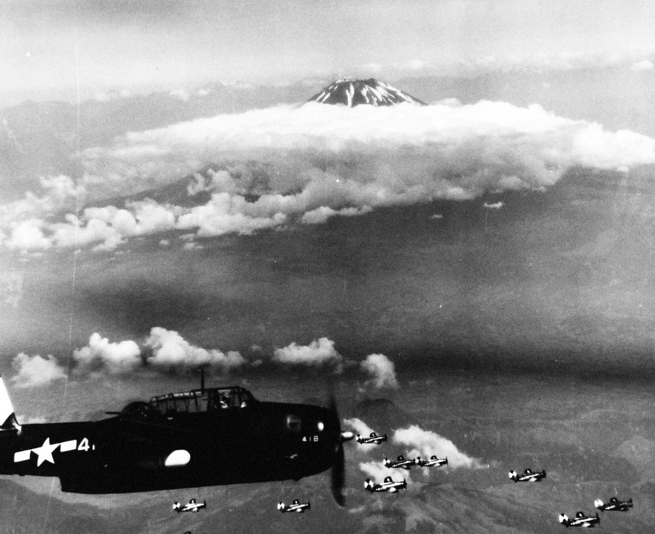 80-G-490231: Raids on Japanese Home Islands, July 10, 1945. USS Essex (CV-9) based TBMs and SB2Cs with Mt. Fujiyama, Japan, in the background.