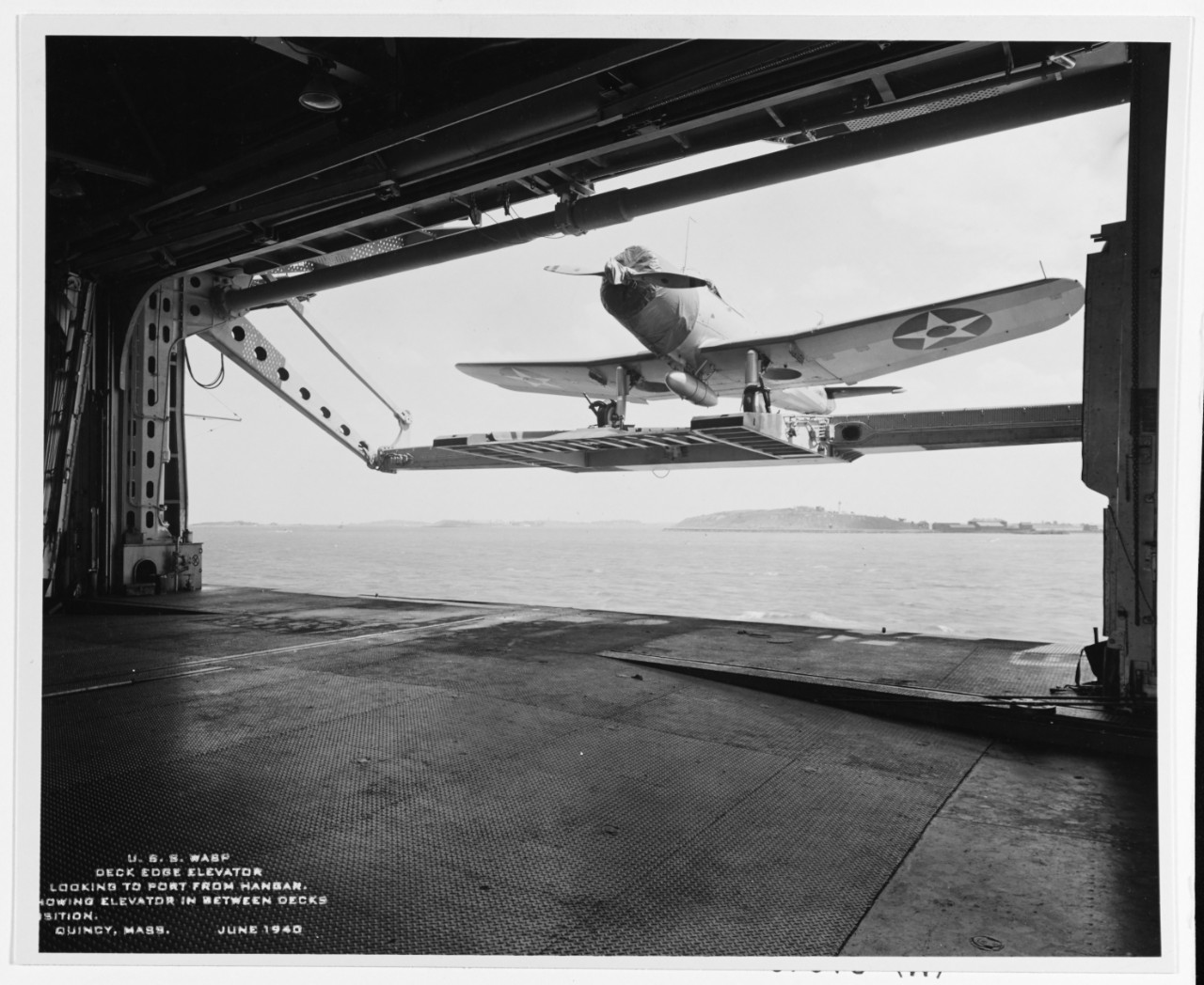 USS Wasp (CV-7). View of deck edge elevator in the between decks position, taken June 1940. Plane on elevator is a Vought SB2U “Vindicator.” Naval History and Heritage Command, NH 43466.