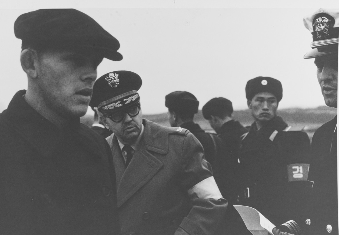 One of Pueblo's crewmen (left) checks in after crossing the Bridge of No Return at the Korean Demilitarized Zone, on 23 December 1968.