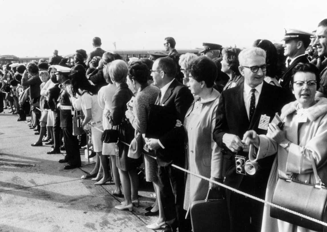 Families of the crewmembers of USS Pueblo (AGER-2) await the arrival of a plane bringing the men to Naval Air Station Miramar, California, 24 December 1968. Click image to download.