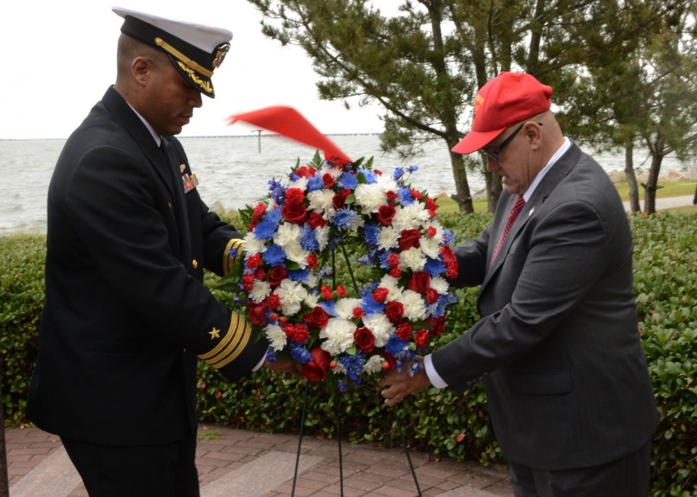 <p>Cmdr. Mikal Phillips, USS<i> Mason</i> (DDG-87) commanding officer, and retired Command Master Chief James Parlier place a wreath at the <i>Cole </i>Memorial during the USS <i>Cole </i>(DDG-67) commemoration at Naval Station Norfolk. Phillips was the fire control officer and Parlier was the CMC aboard during the attack. Although <i>Cole</i> and her crew are currently deployed, more than 150 former and current crew members, along with relatives, family members and naval officials, gathered together to pay tribute to the 17 Sailors killed and 39 wounded in the attack on the ship 14 years ago.(U.S. Navy photo by Mass Communication Specialist 3rd Class Amber O'Donovan/Released)&nbsp;</p>
