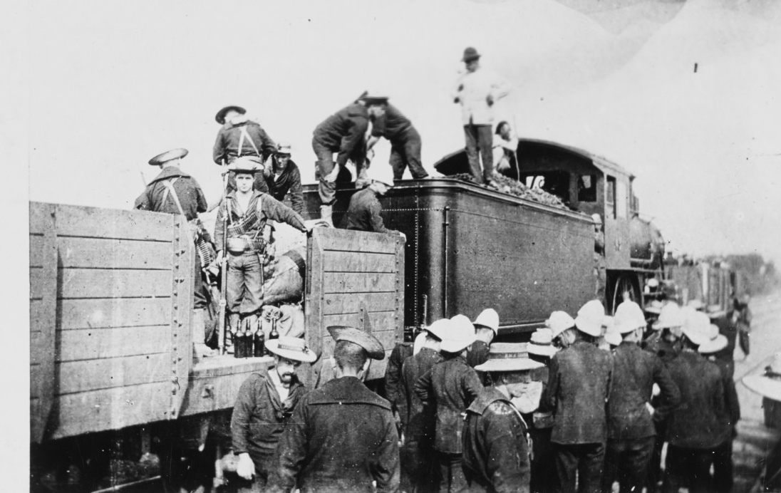 Sailors surrounding a train. Clicking this linked image leads to a page where the photograph can be downloaded.
