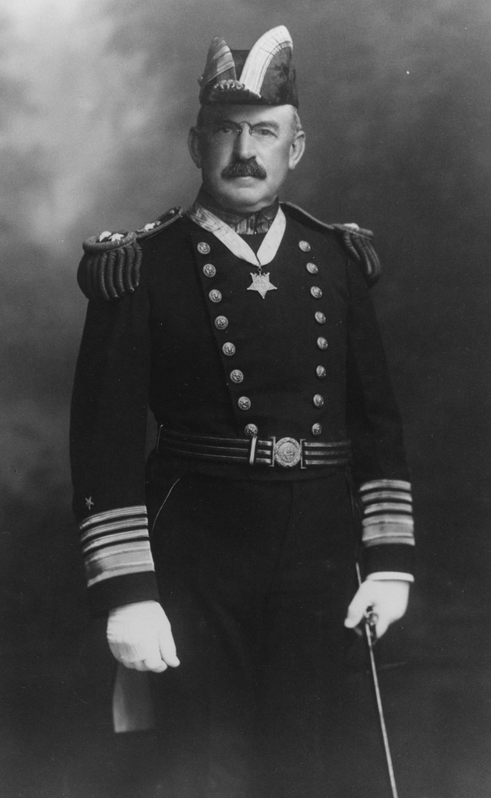 Portrait photo of a uniformed admiral wearing a star-shaped medal on a ribbon around his neck. Clicking on this image directs to a page to download the image.
