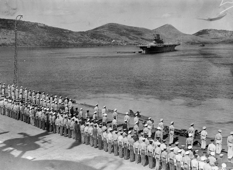 Royal Navy personnel mustered on the flight deck of HMS Victorious on 27 July 1943, four days before departing Noumea, New Caledonia, and U.S. Navy service