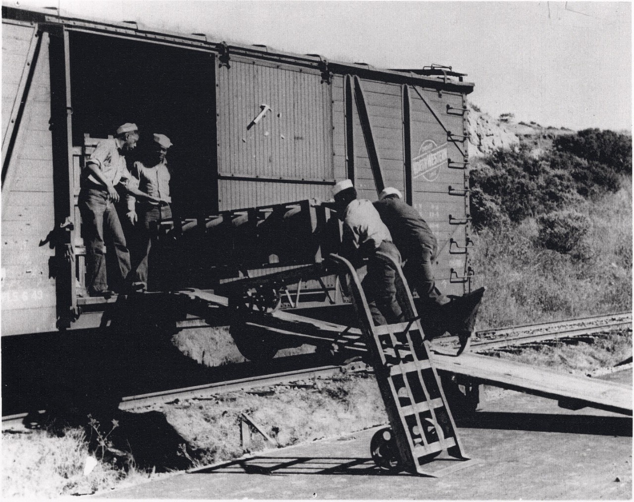 <p>African American sailors of an ordnance battalion unload aerial bombs from a railcar, Port Chicago Naval Magazine, circa 1943/44.</p>

