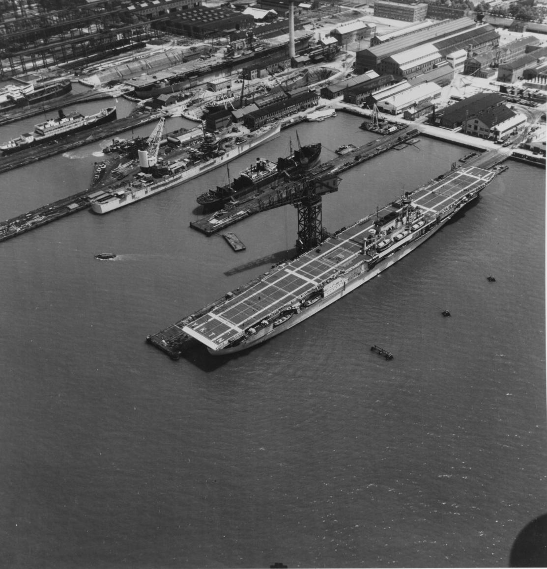 The USS Yorktown (CV-5, foreground) in June 1937, preparing for sea trials at Newport News Shipbuilding, while the Enterprise (CV-6) is fitting out in a drydock (upper center). Both carriers were purchased far in advance of World War II and playe...
