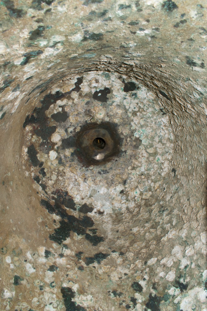 Marine concretions such as barnacles on the interior of the USS Utah bell, likely from its time submerged at Pearl Harbor.