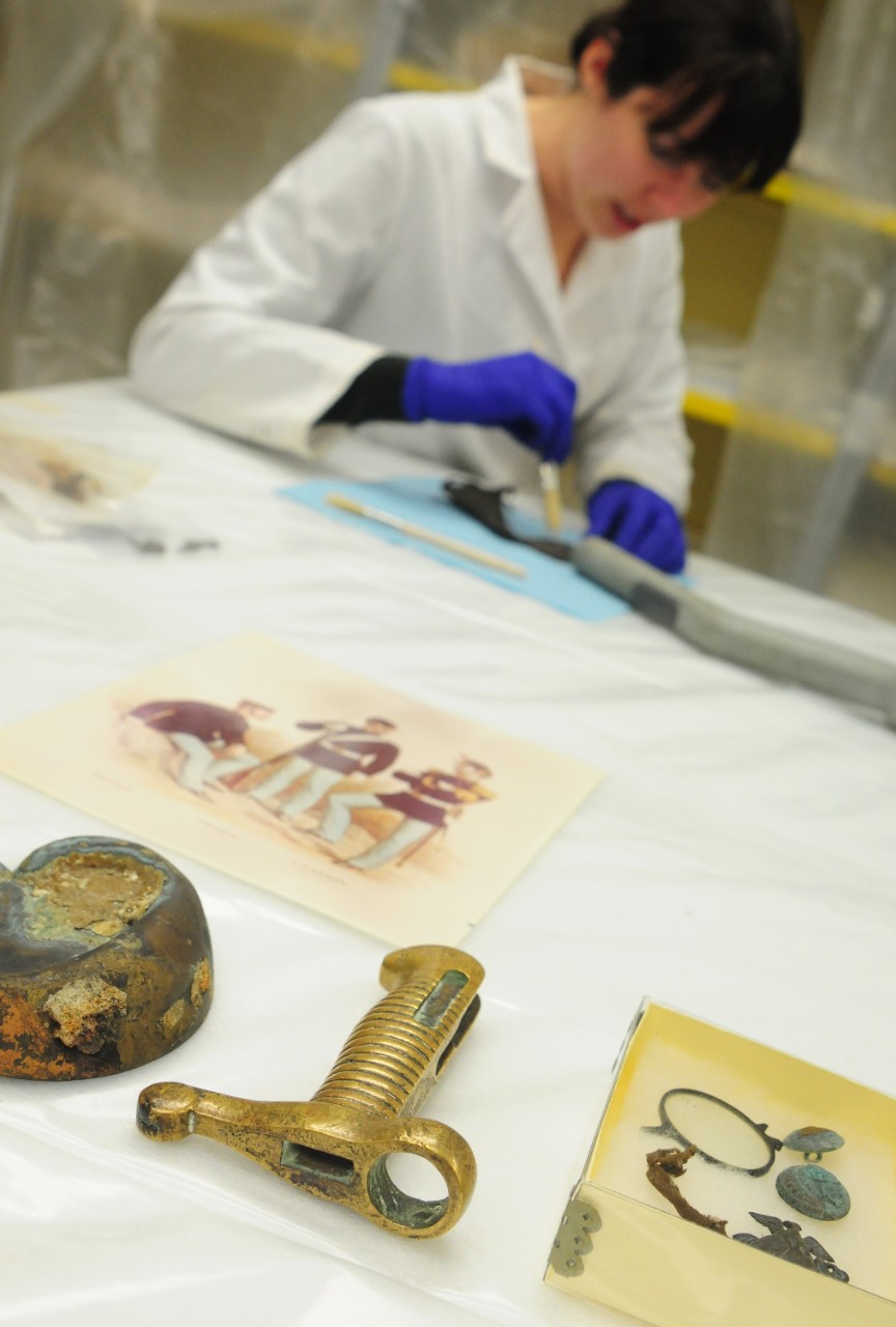 Kate Morrand, archaeological conservator for the Archaeology & Conservation Laboratory at Naval History and Heritage Command, cleans artifacts recovered from the wreck of USS Huron.