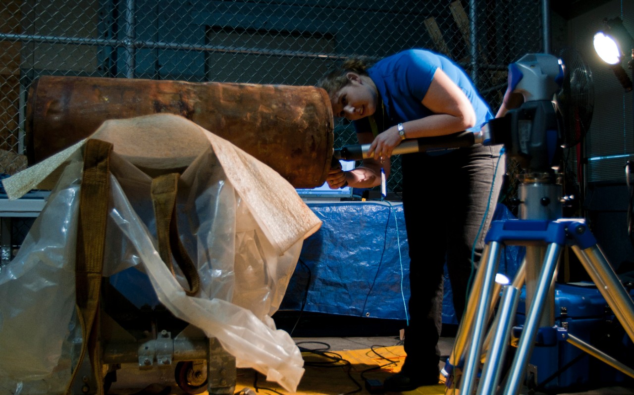 Caitlin Swec, a project engineer at Naval Surface Warfare Center Carderock Division, makes a 3-dimensional scan of the number 24 Howell Torpedo.
