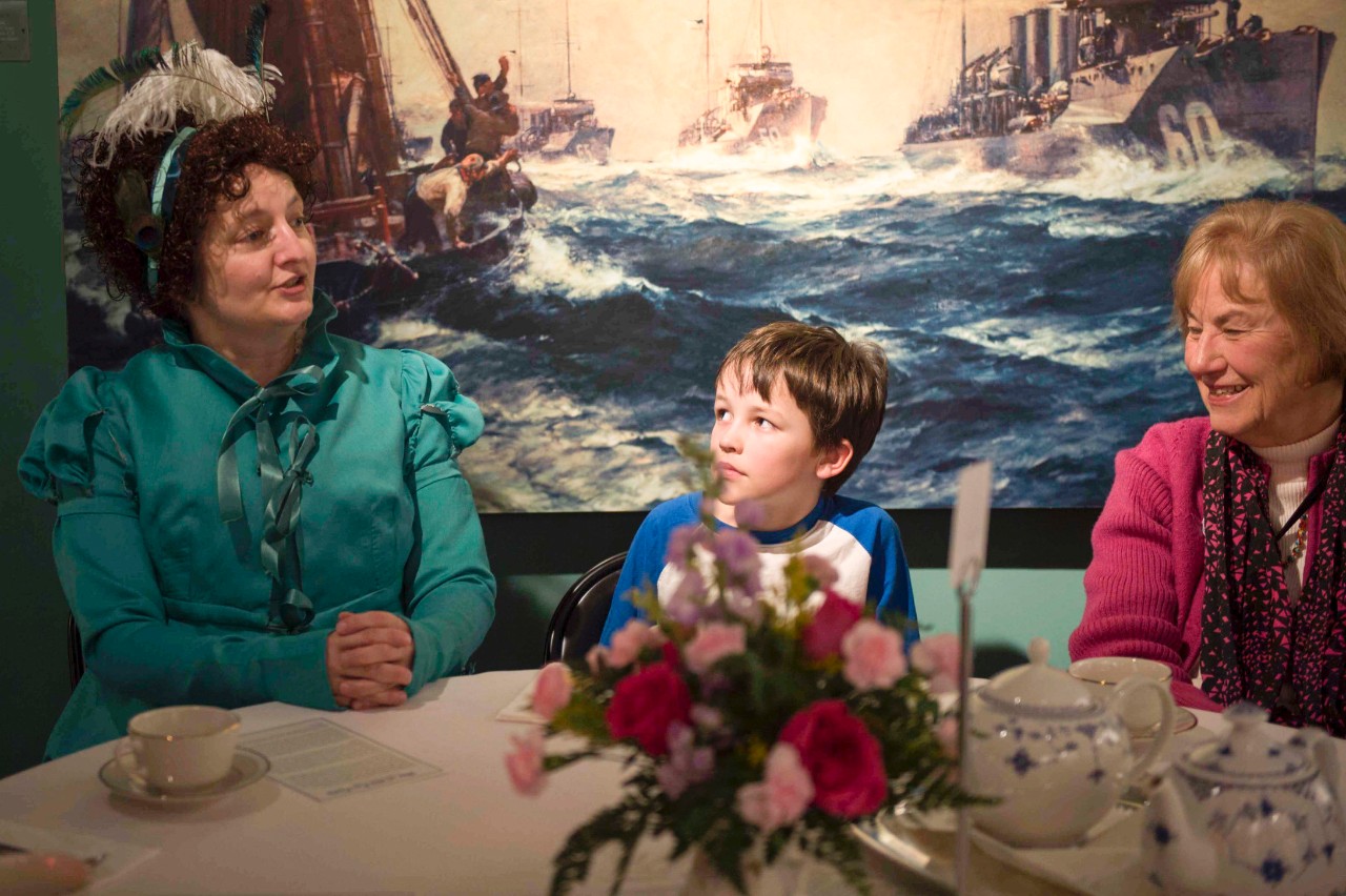 Period re-enactor Katherine Spivey, from the Virginia Regency Society, speaks with a table during the Hampton Roads Naval Museum's tea party event.