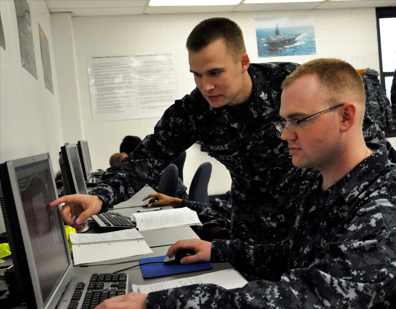 Hull Technician 1st Class Nolan R. Nichols, the 2001 Shore Sailor of the Year at the Center for Naval Engineering Learning Site, Great Lakee, answers a question on the computer-based training system with a student.