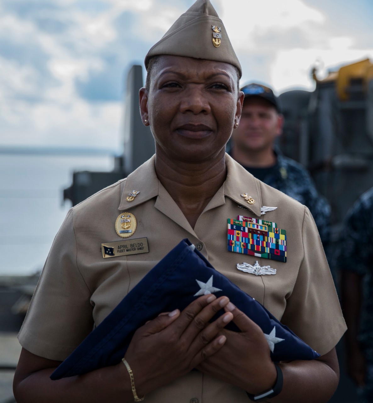 Fleet Master Chief April Beldo, Manpower, Personnel, Training, and Education (MPT&E), receives a flag from a Sailor aboard the Nimitz-class aircraft carrier USS Abraham Lincoln (CVN 72). The flag was flown in honor of her father. During her visit...