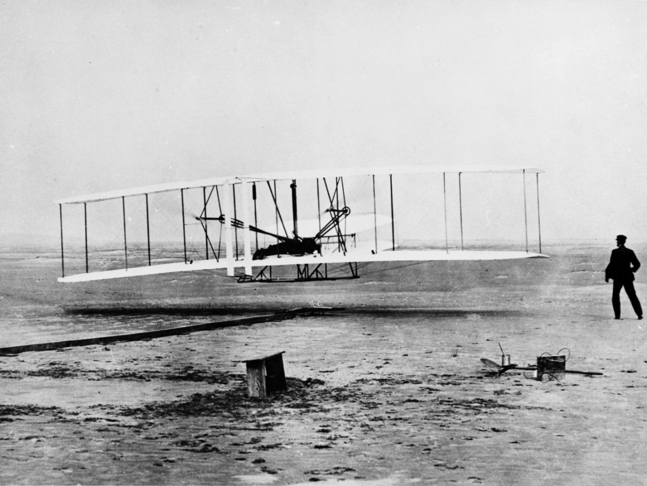 Orville Wright pilots the Wright Flyer in the first manned powered flight, at Kitty Hawk, North Carolina, 17 December 1903