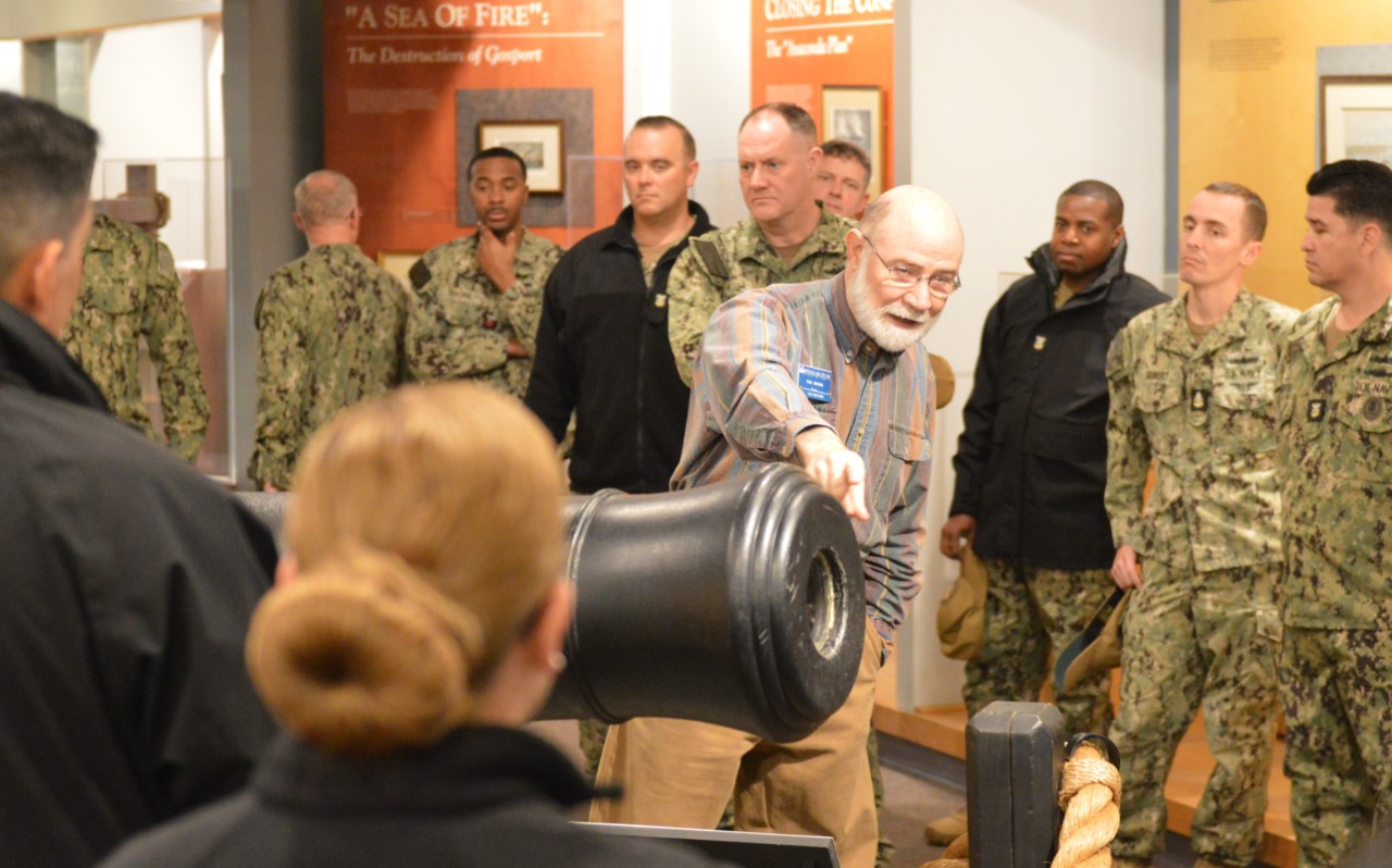 Rick Brown, a volunteer docent at the Hampton Roads Naval Museum (HRNM), provides a guided tour through the museum’s gallery to Sailors assigned to Naval Medical Forces Atlantic (NMFL).