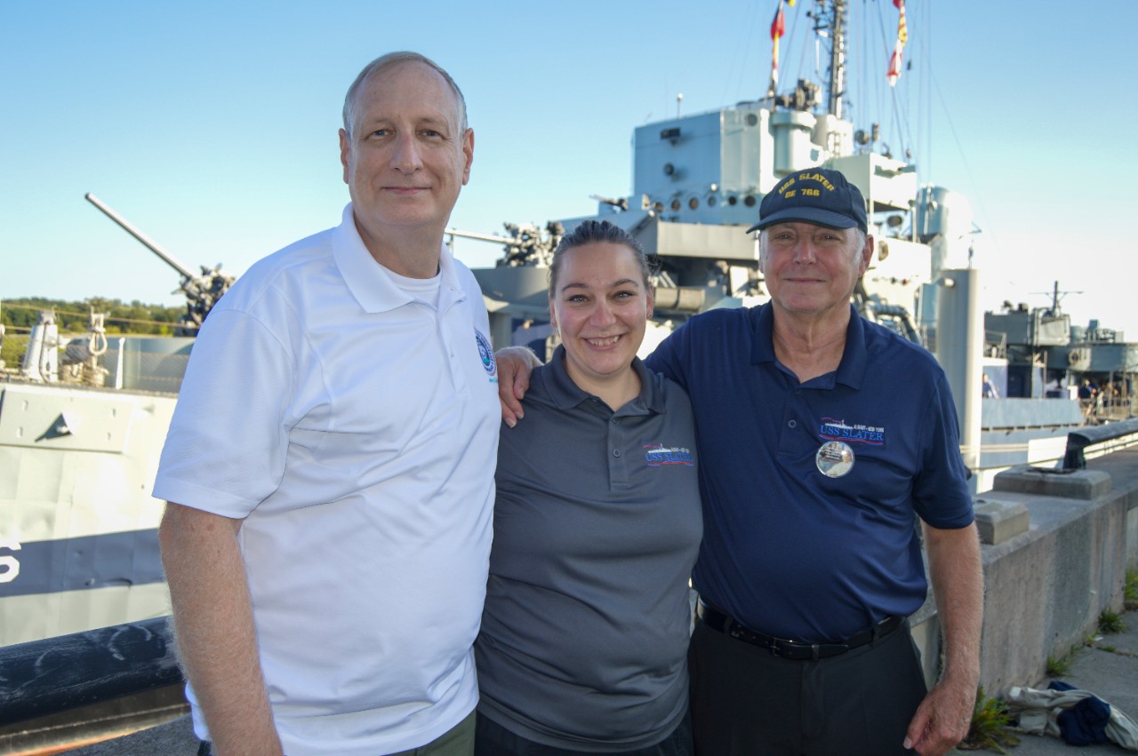 Naval History and Heritage Command’s Deputy Assistant Director for Museums Division and retired naval aviator, Jeff Barta, stands with USS SLATER DE-766 Program Manager Shanna Shuster and Executive Director Tim Rizzuto beside the historic ship mu...