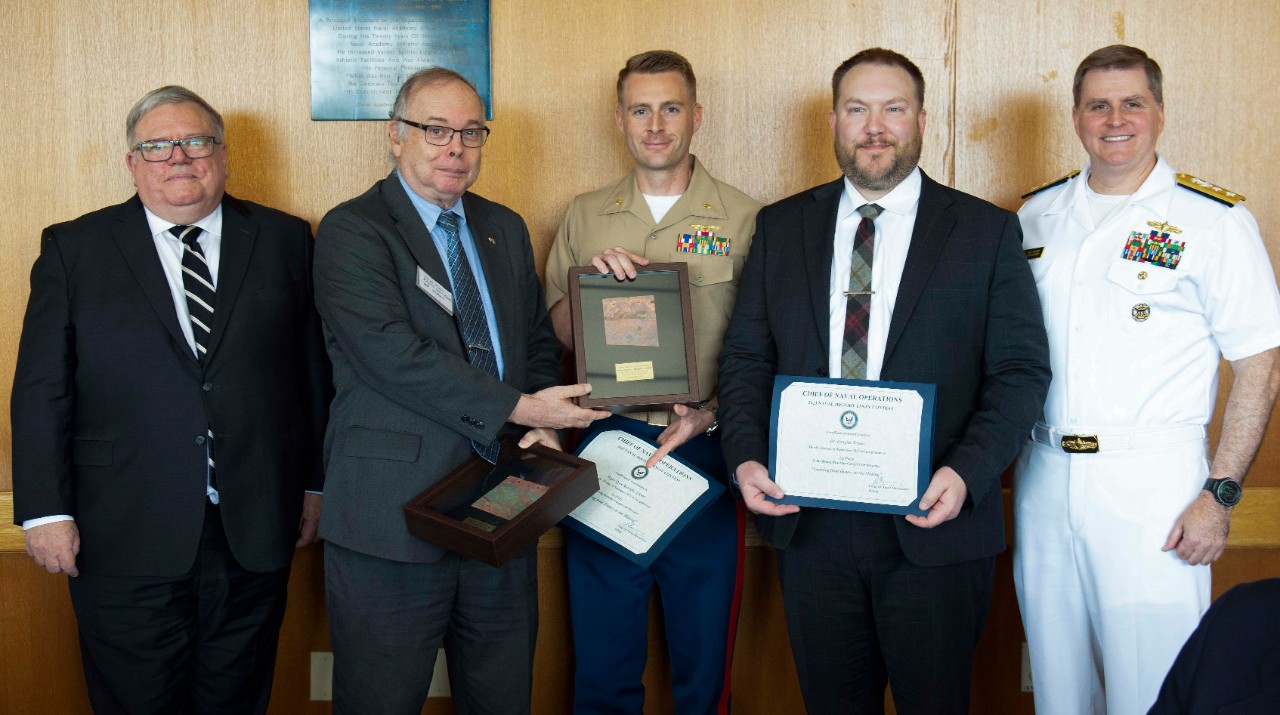 Rear Adm. Fred Kacher, acting Superintendent for the Naval Academy; Naval History and Heritage Command Director, retired Rear. Adm. Sam Cox, and Chief Executive Officer of the U.S. Naval Institute, retired Vice Adm. Peter H. Daly present awards t...