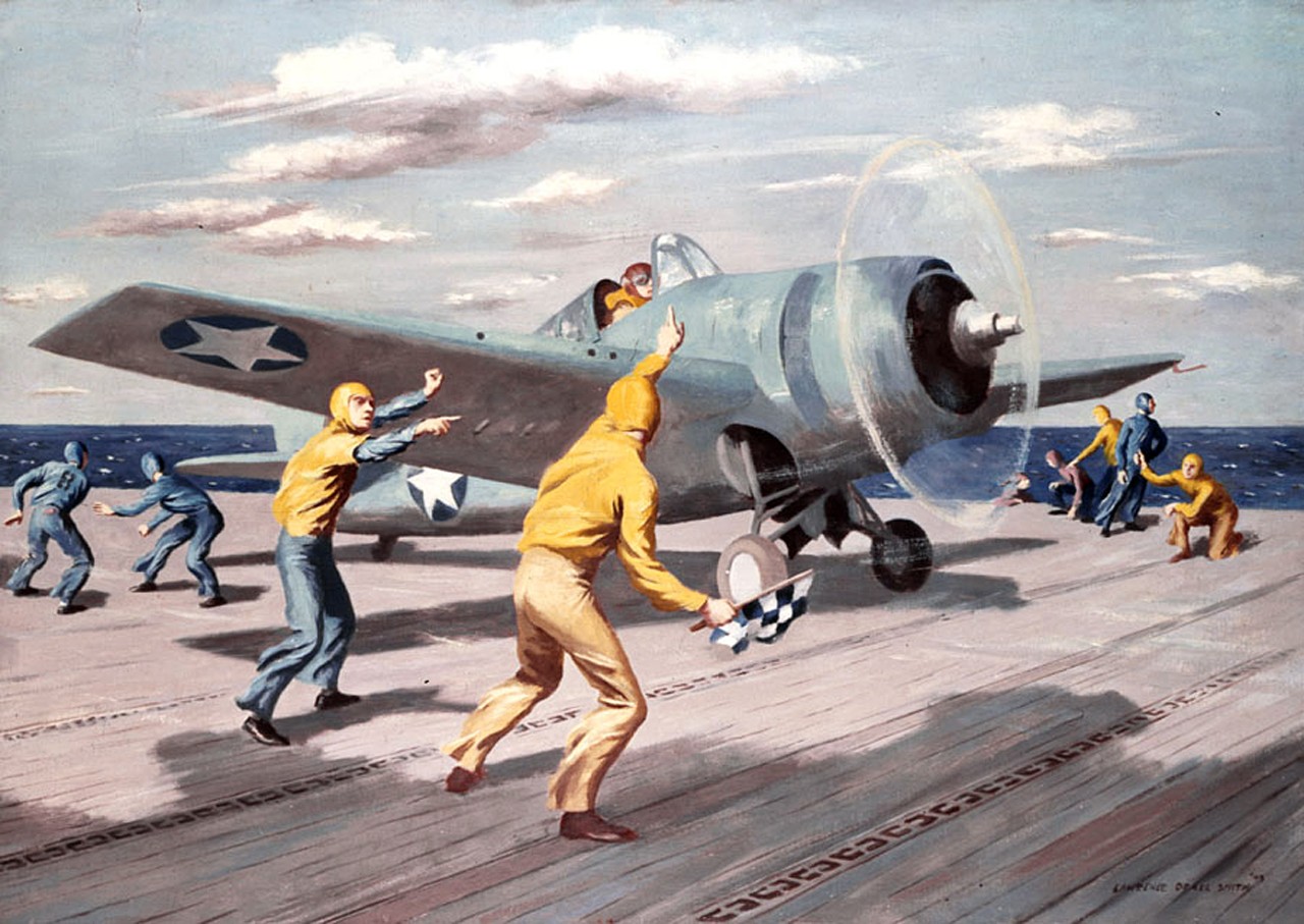 Deck crew is launching a plane off of a carrier