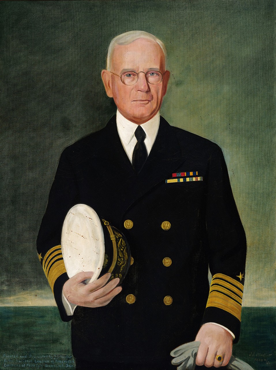 Admiral William H. Standley in dress blues holding his hat in one hand and gloves in the other