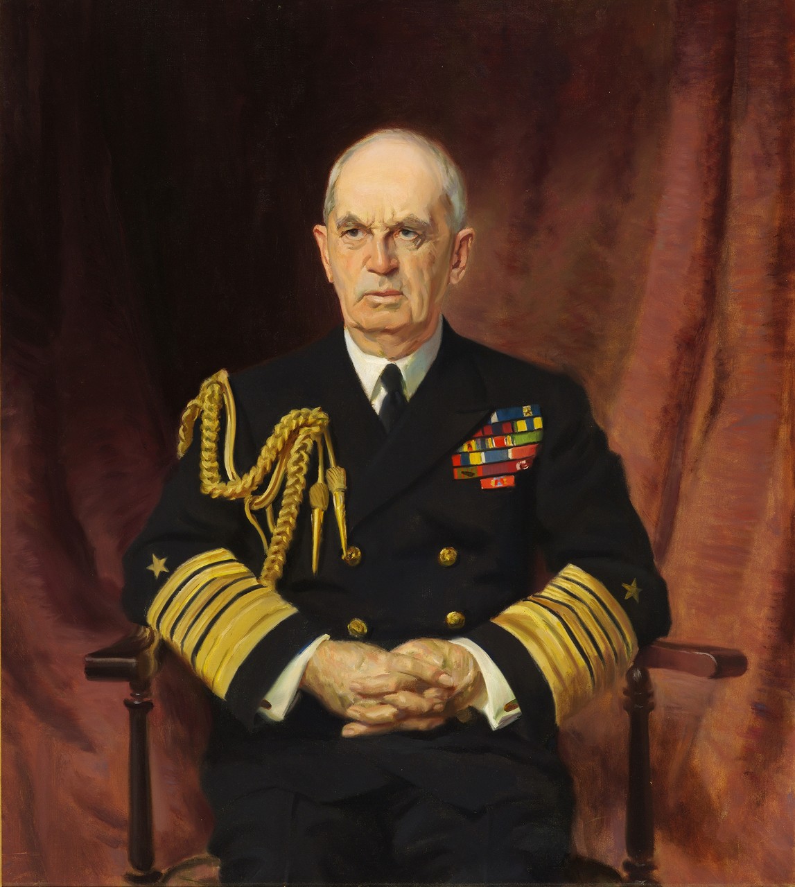 Admiral William Leahy is seated in a chair wearing dress blues