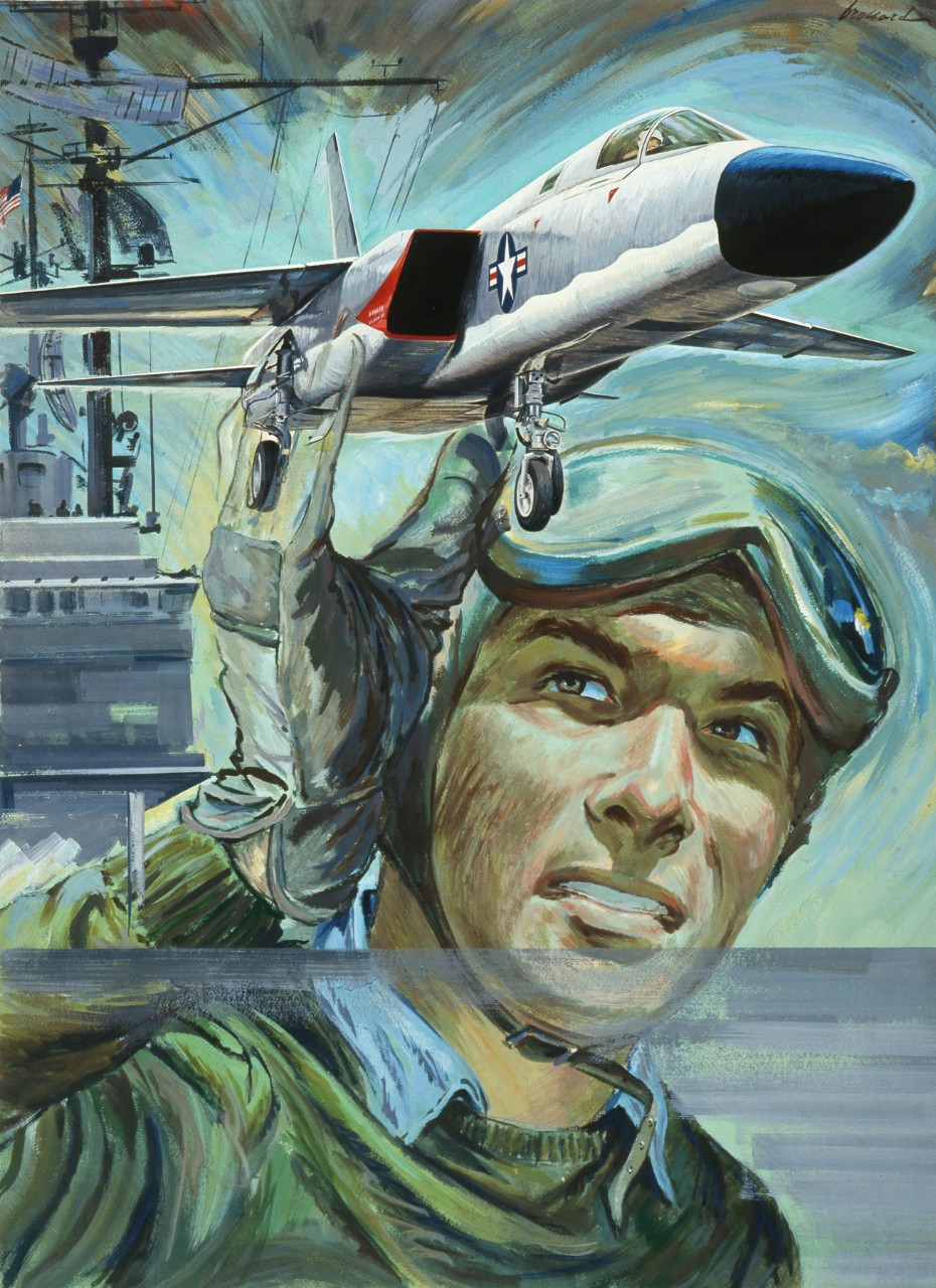 A close up of a deck crewman on an aircraft carrier while a plane is flying above him.