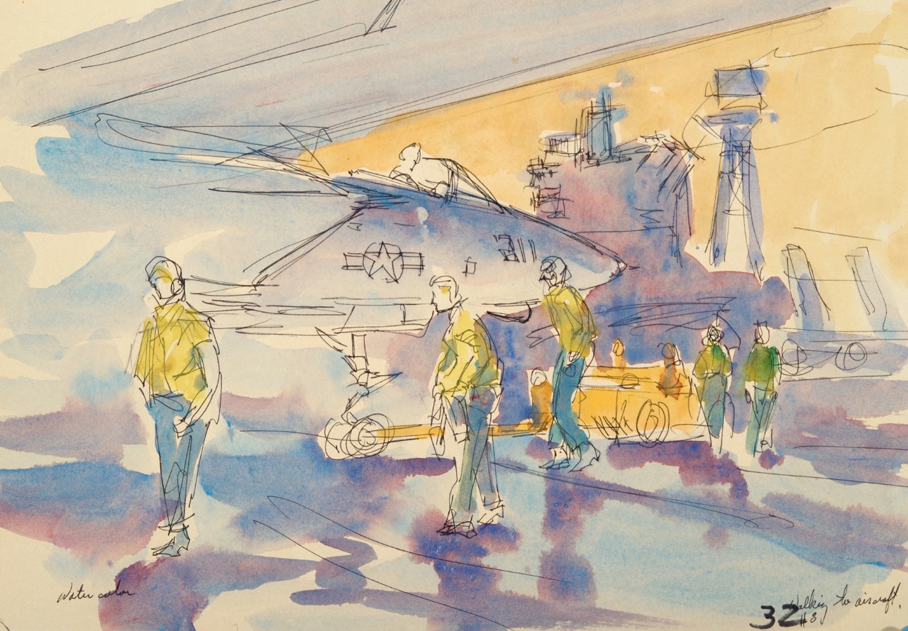 Crewmen on the deck of an aircraft carrier ready a plane